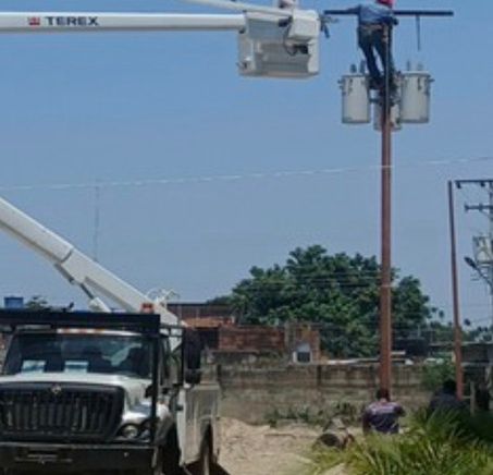 Cuadrilla instalando transformadores en un poste desde un camión cesta